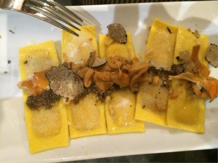 Ravioli di pasta fresca ai funghi porcini e finferli su crema di pecorino e tartufo nero estivo