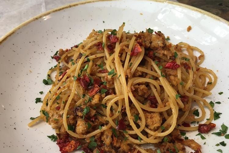 Spaghetti aglio, olio e peperoncino con acciughe, uva sultanina e briciole di pane