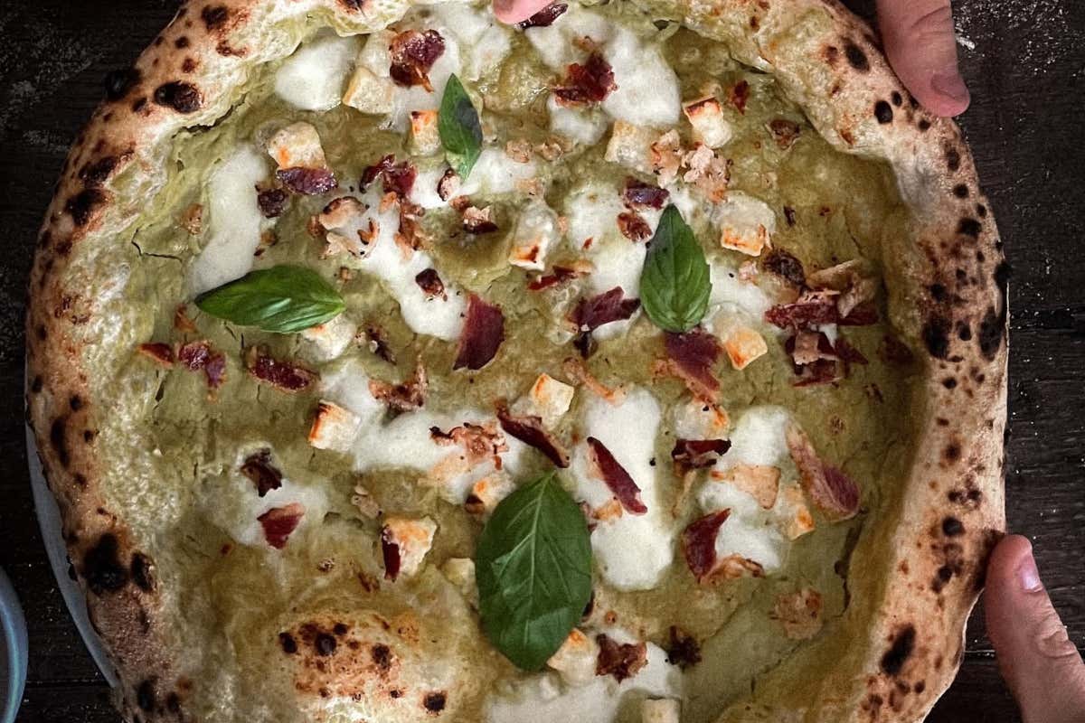 La pizza Peace, crema di piselli vellutata, provola affumicata filante, scorzette di parmigiano reggiano, pancetta croccante