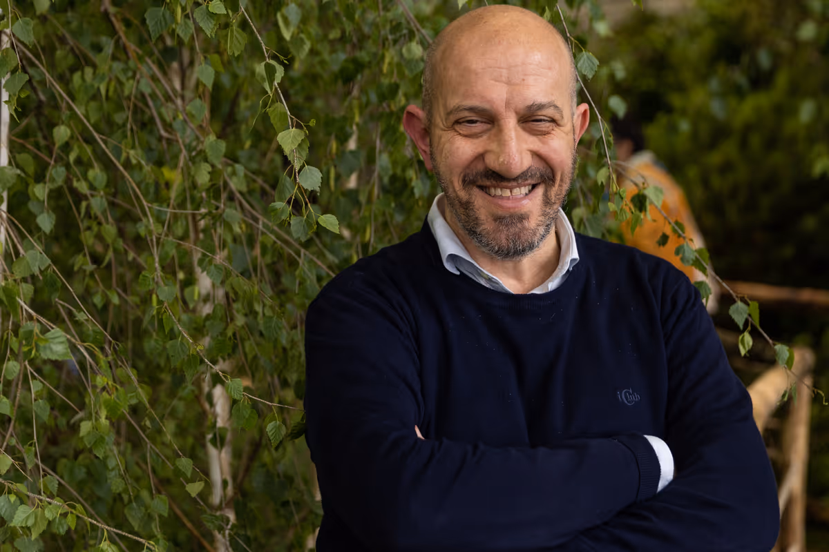 Il gastronomo e critico Alberto Grandi sorride davanti a un albero