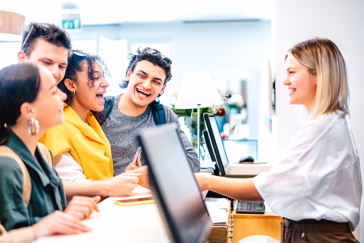 un gruppo di turisti sorridenti al check-in alla reception di un hotel
