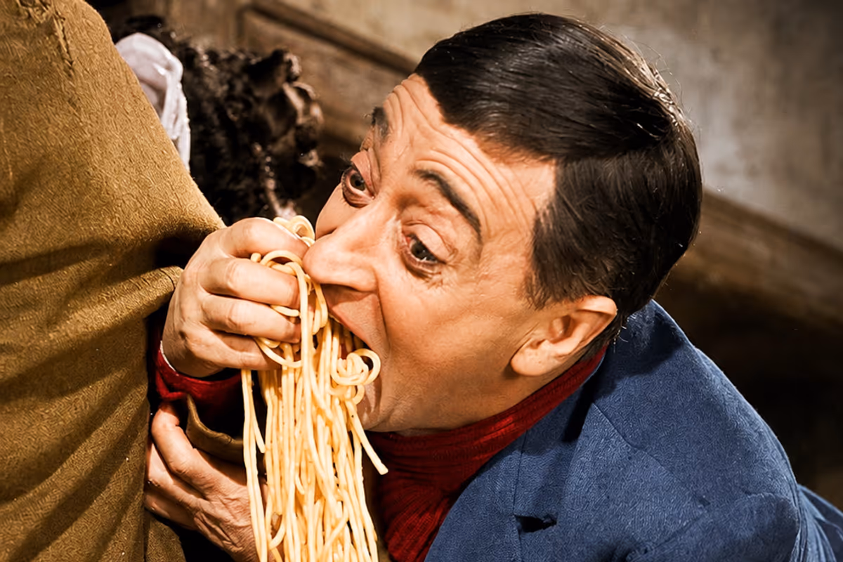 L'attore Totò mangia un abbondante piatto di spaghetti con le mani