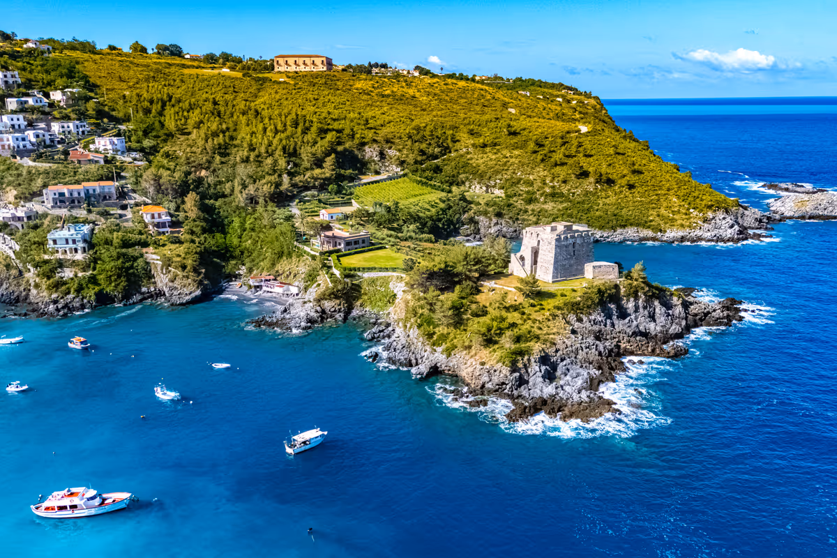 Costa calabrese con un'antica torre costiera affacciata sul mare turchese