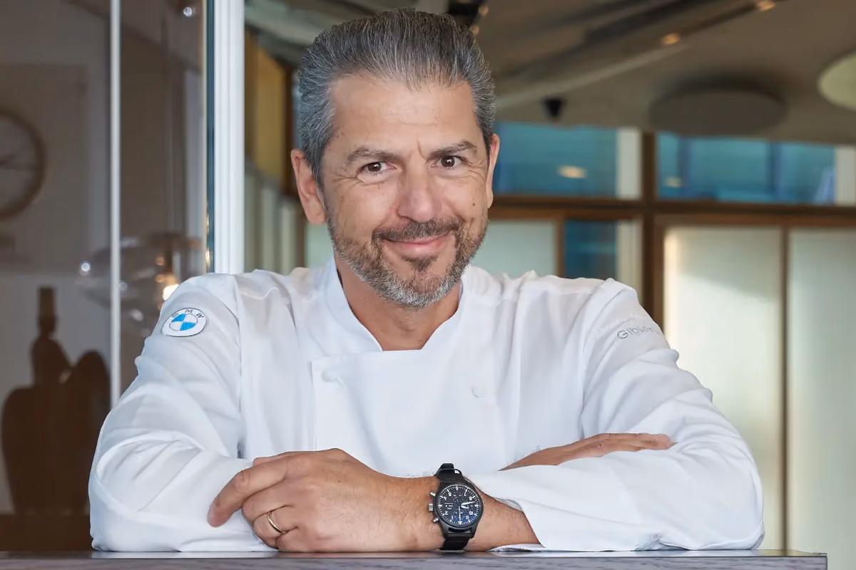 Lo chef Andrea Berton con giacca bianca da cucina in una sala
