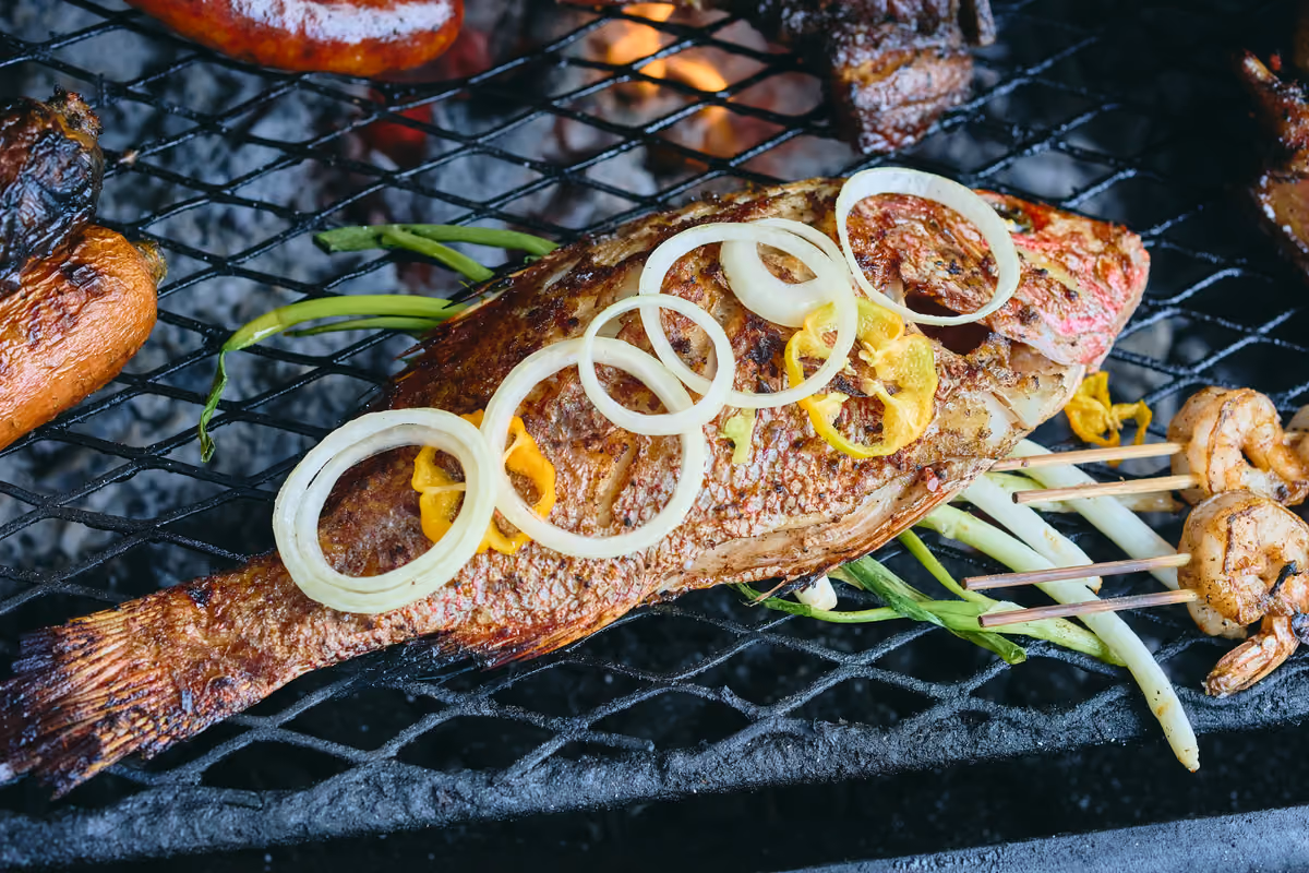 Pesce fresco grigliato con anelli di cipolla e peperoncino Scotch Bonnet, un'altra variante immancabile della cucina locale
