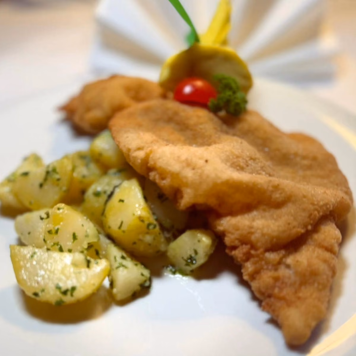 la classica Wiener Schnitzel di vitello con patate al prezzemolo e confettura di mirtilli