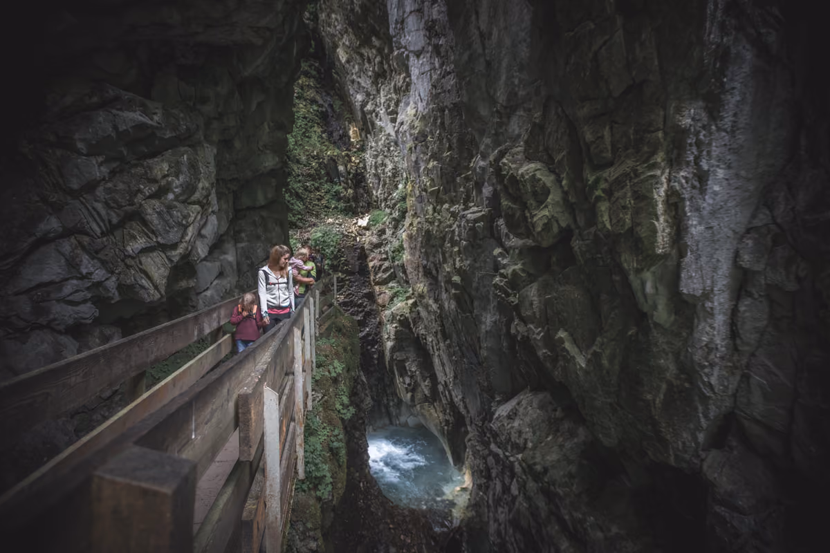 Escursionisti lungo le passerelle in legno delle spettacolari Gole di Stanghe (Gilfenklamm), l'unico canyon al mondo scavato interamente nel marmo bianco