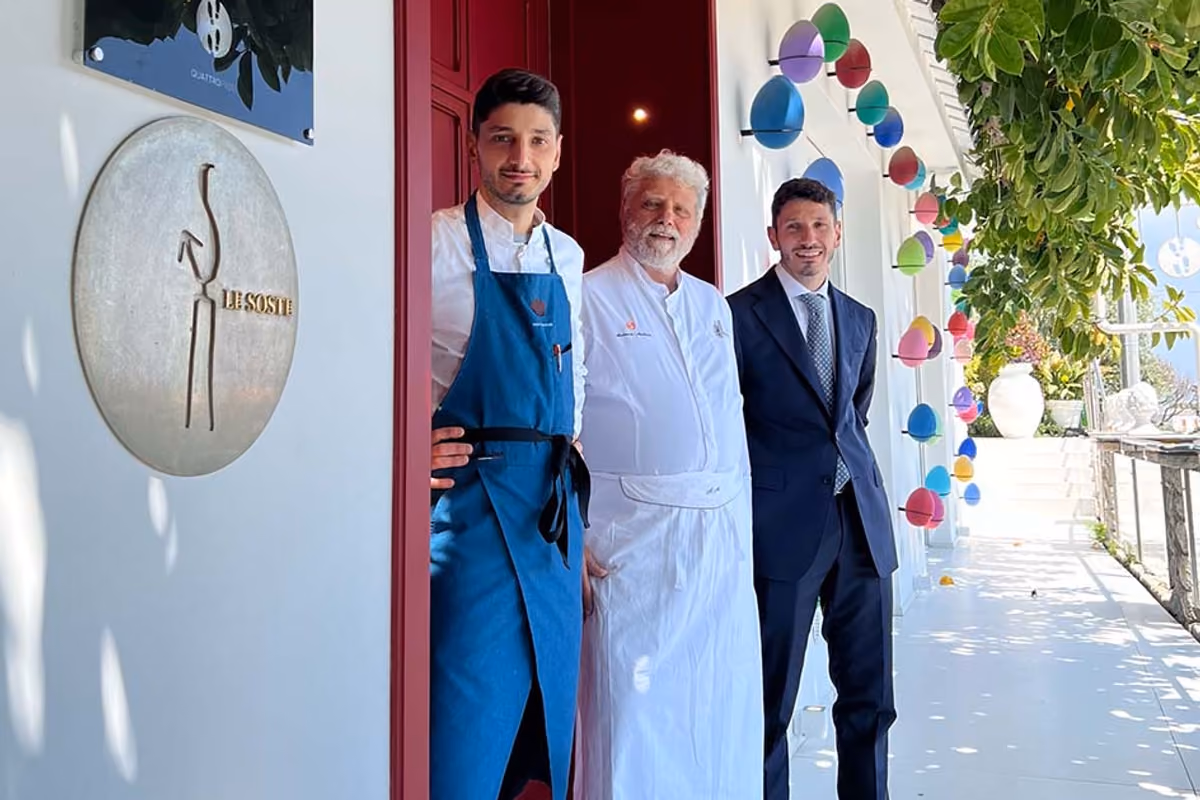 Tre uomini in abbigliamento professionale posano davanti all'ingresso del ristorante Quattro Passi