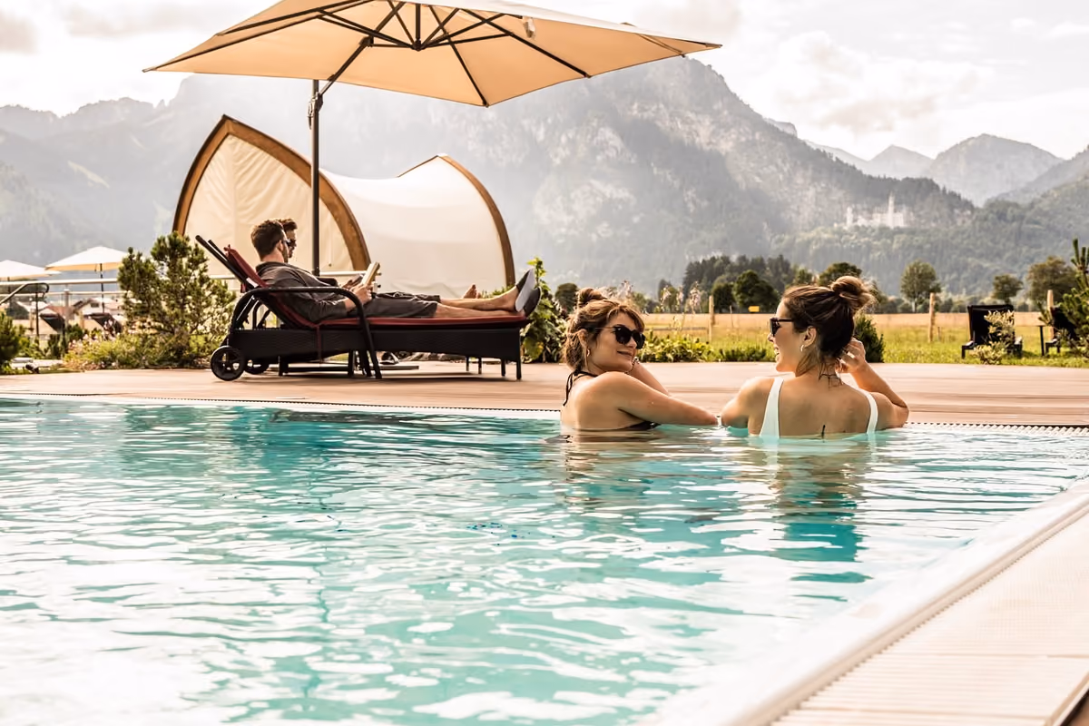 Due donne nella piscina con vista sul castello di Neuschwanstein in Baviera