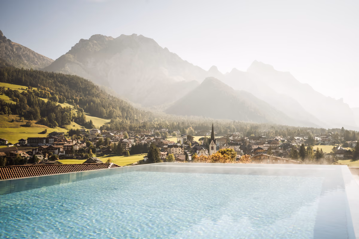 piscina a sfioro con vista panoramica sul paese e le Dolomiti in Val Badia
