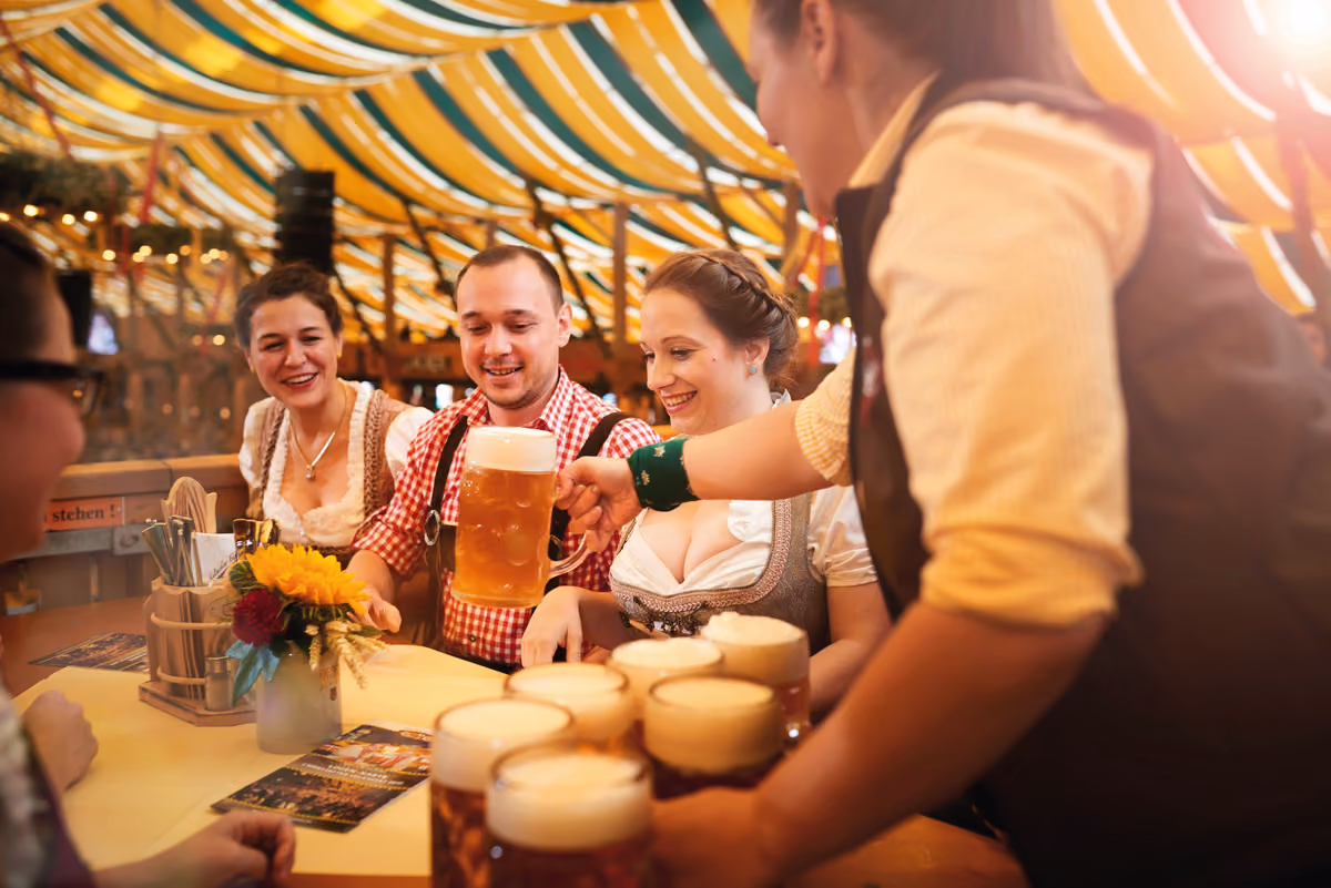 Un boccale di birra servito ai tavoli: la convivialità e la festa tipiche dell'accoglienza bavarese