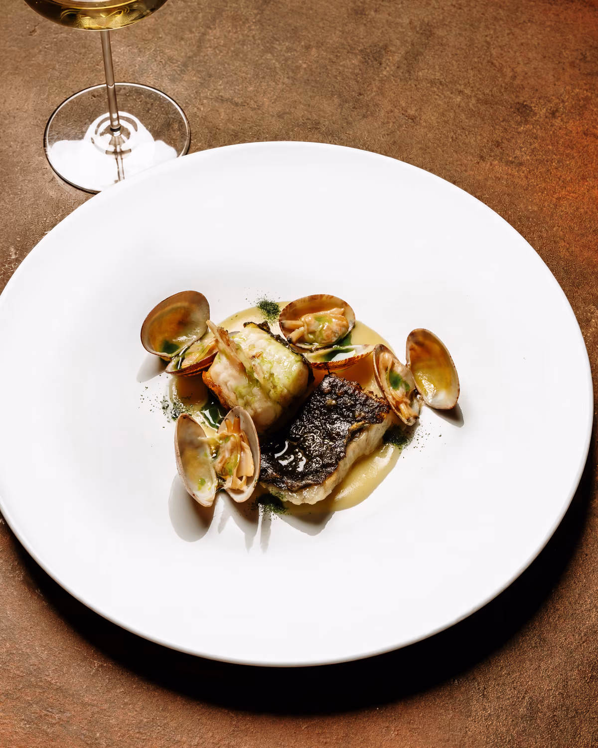 Costina di rombo scottata, vongole veraci, salsa di vongole e olio al cipollotto