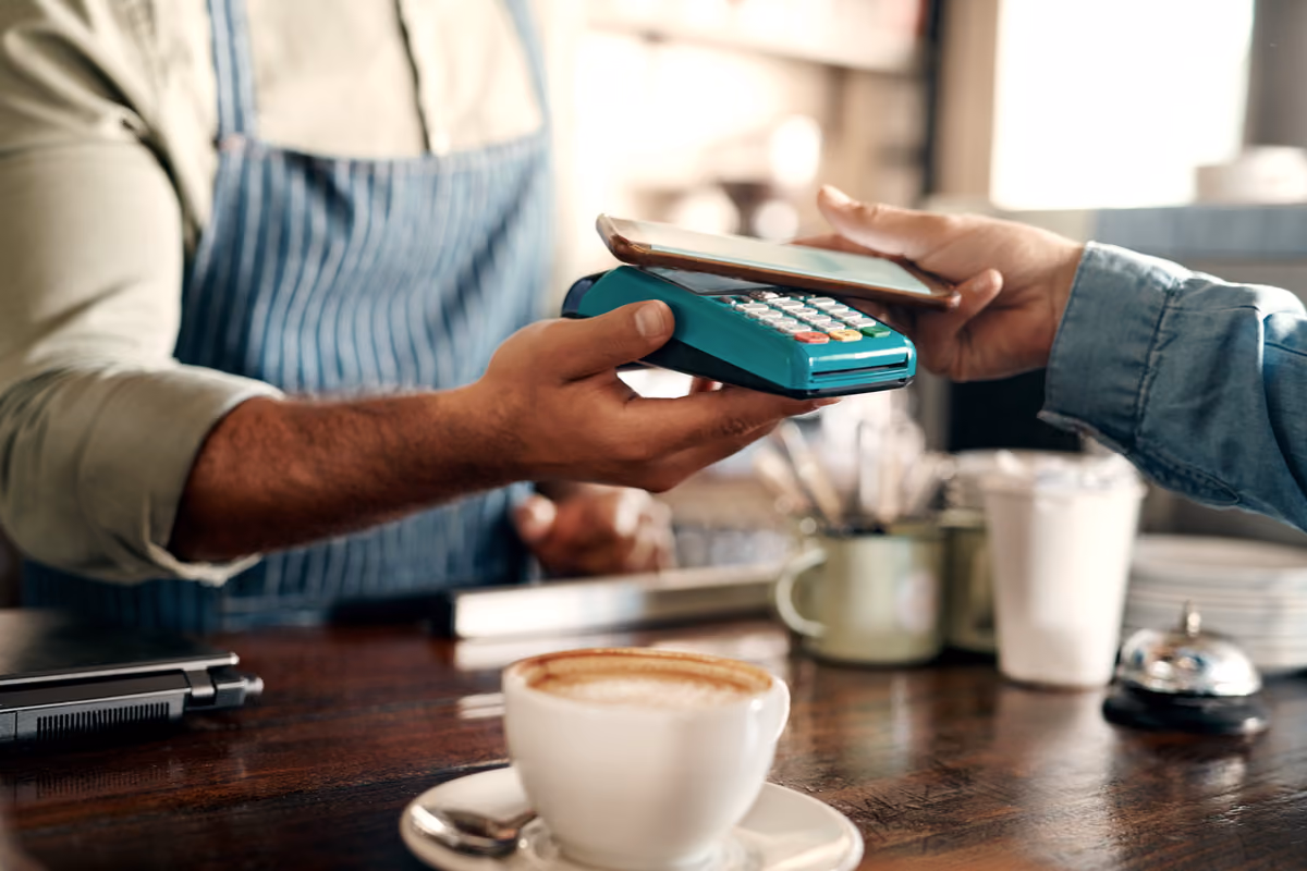 cliente paga con smartphone su un terminale pos in una caffetteria