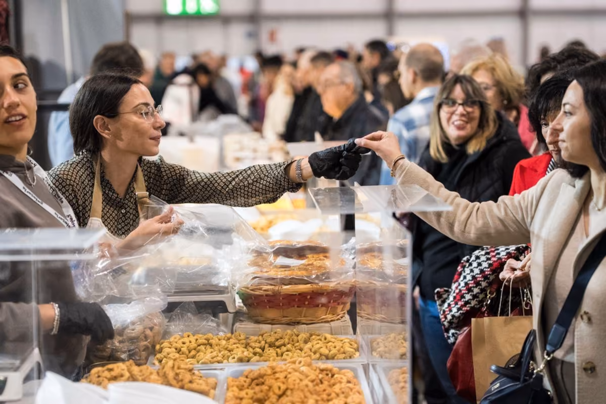 banchetto di dolci e prodotti da forno al mercato Golosaria con consumatori