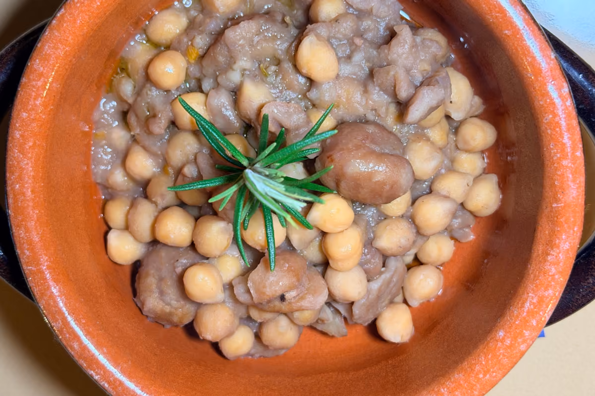 zuppa di ceci e castagne servita in un tegame di terracotta con rosmarino fresco