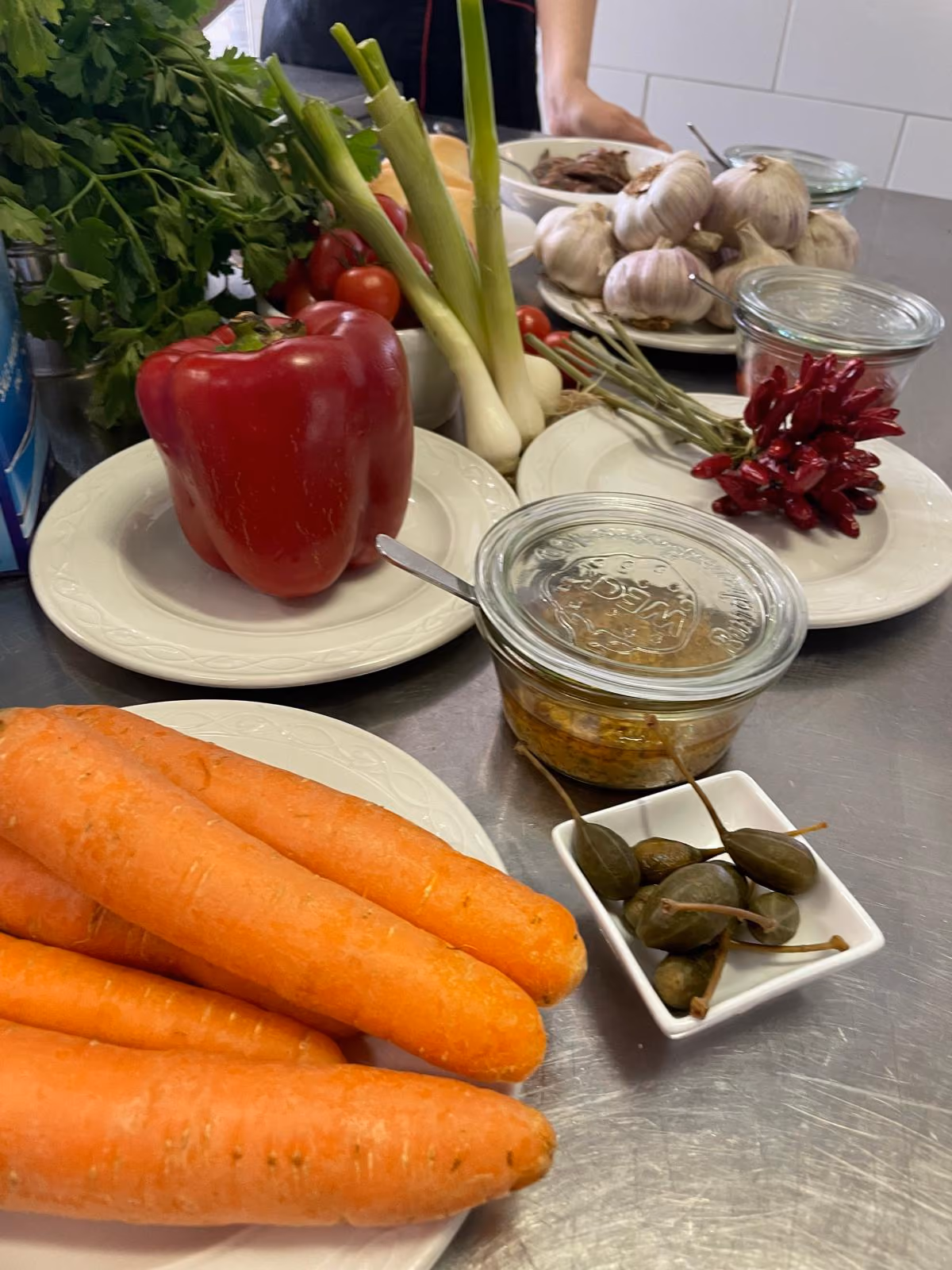Il segreto delle salse: ingredienti freschi e di stagione, come prezzemolo, peperone, aglio, acciughe e capperi, pronti per essere trasformati nei classici "codici" che accompagnano il Gran Bollito (bagnetto verde, bagnetto rosso, salsa rubra)