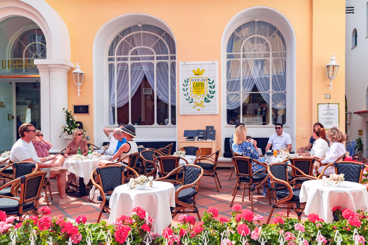 Clienti seduti ai tavoli esterni del Grand Hotel Quisisana a Capri