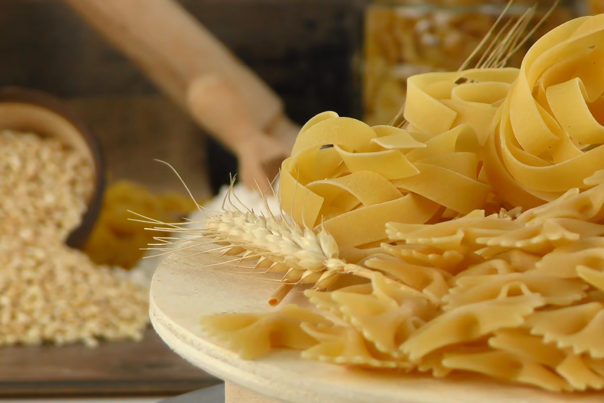 Pasta secca cruda formati farfalle e nidi con una spiga di grano