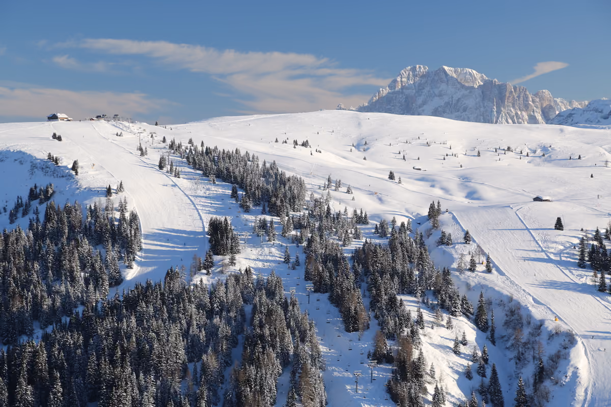 Piste da sci innevate ad Arabba con le vette delle Dolomiti sullo sfondo