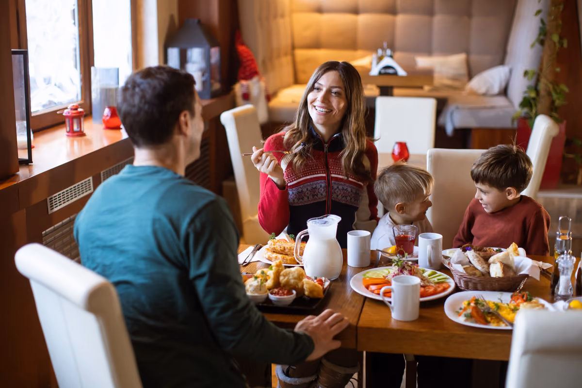 famiglia sorridente a tavola durante il pranzo in un ristorante