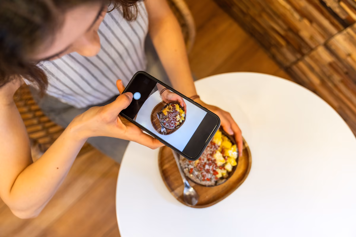 Fotografie dei piatti, messaggi e social network hanno reso lo smartphone una presenza abituale anche durante i pasti al ristorante