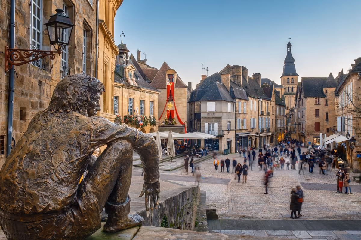 Statua di bronzo che osserva la piazza centrale medievale di Sarlat