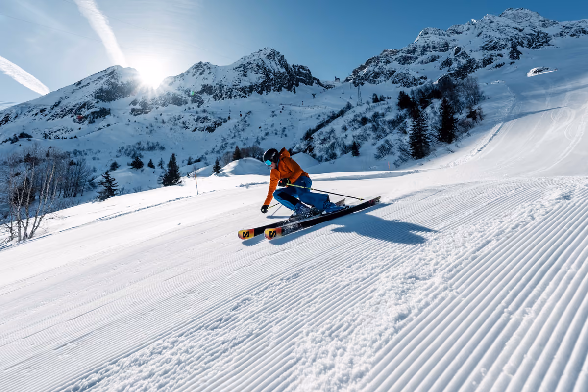 sciatore in tuta arancione su pista innevata nel comprensorio Pontedilegno-Tonale