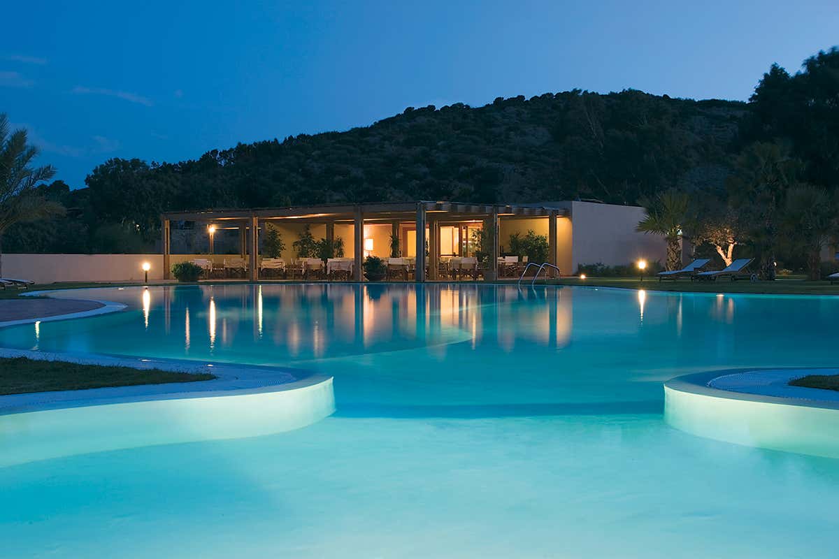 Dopo una cena a lume di luna, la lunga spiaggia di Su Giudeu a Chia diventa il teatro perfetto per osservare il plenilunio specchiarsi nel mare cristallino
