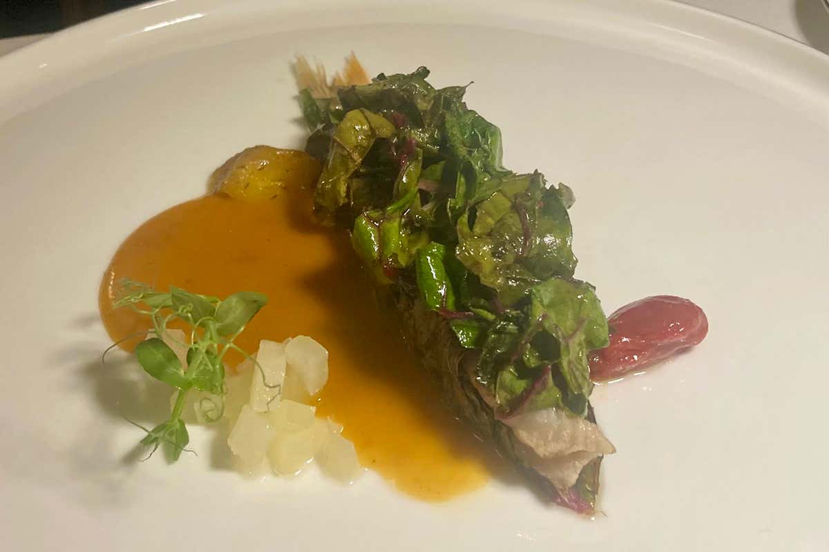 La Triglia ripiena di olive taggiasche, acciughe e capperi, servita con una riduzione di lische e teste per un'intensa spinta umami, bilanciata da dadini di limone candito