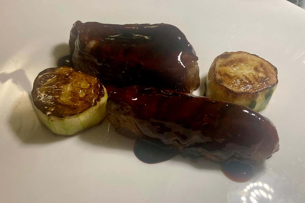 La Pluma di maialino in salsa tarè e miele: un secondo piatto dai sentori balsamici accompagnato da un fresco involtino crudo di cetriolo ripieno di panzanella e sorbetto di mela verde