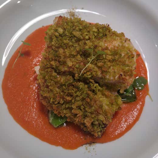 Trancio di ricciola gratinato alle erbe, salsa puttanesca e peperoncini verdi