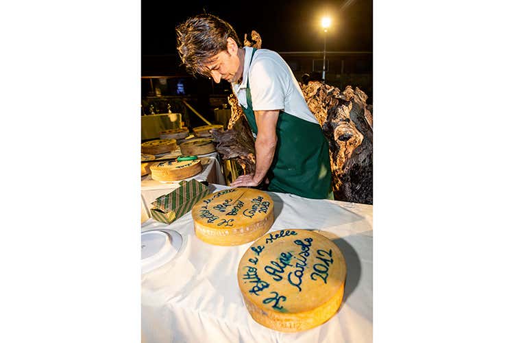 Il momento del taglio delle forme di Bitto Dop (Bitto, piccole eccellenze crescono con l'aiuto delle stelle in cucina)