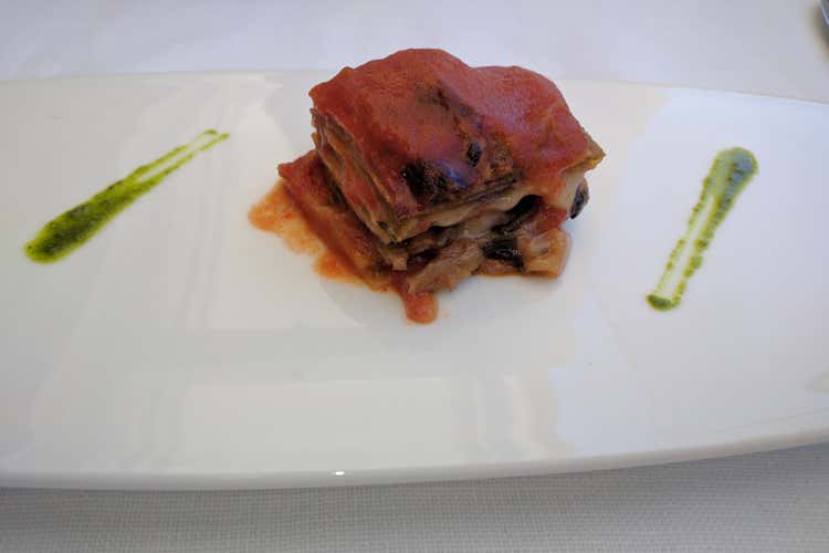 Parmigiana di melanzane con tocchi laterali di pesto al basilico