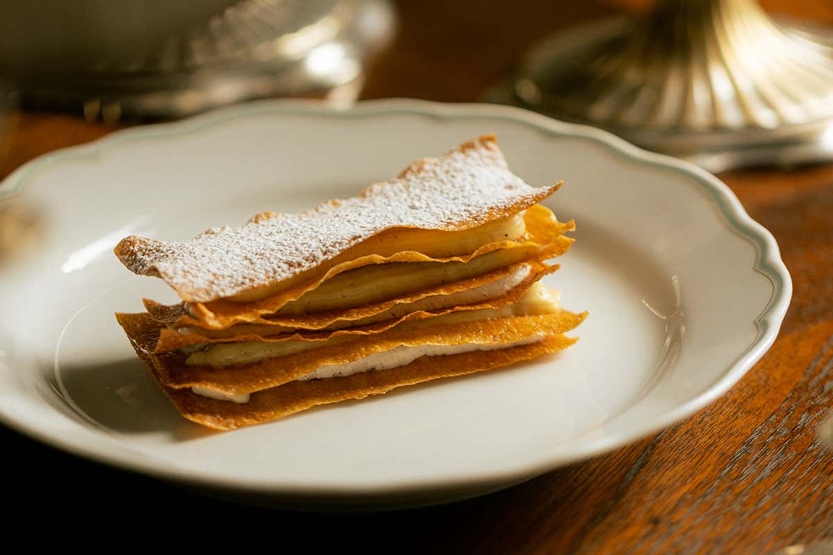 La perfetta stratificazione della millefoglie ai fiori d'arancio che compone la ricca proposta dolce finale