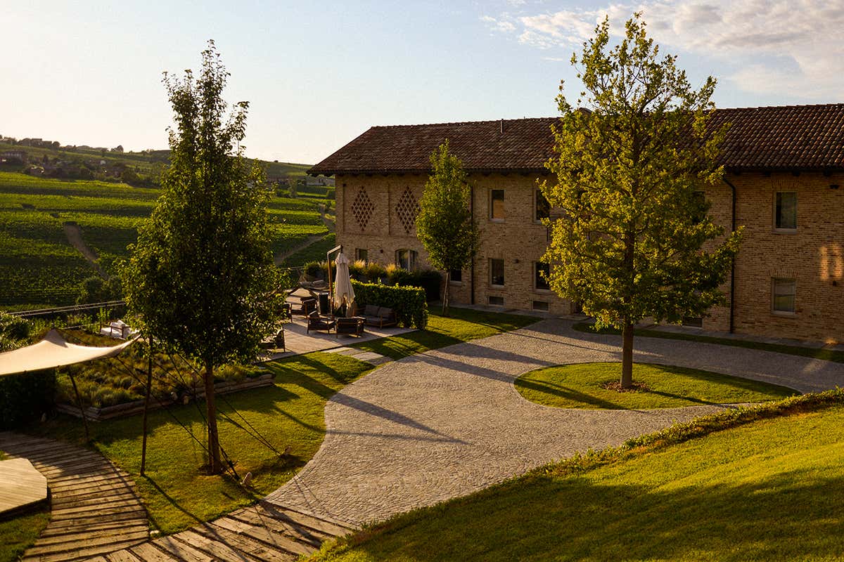 La corte esterna di Le Marne Relais immersa nel paesaggio vitivinicolo di Langhe e Monferrato al tramonto