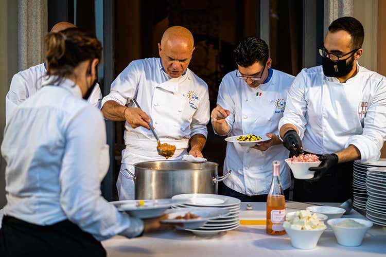Enrico Derflingher e il team di cuochi del nuovo brand catering alle prese con il servizio del Risotto Regina Vittoria - Derflingher riparte col catering Alta cucina tra emozioni e dettagli