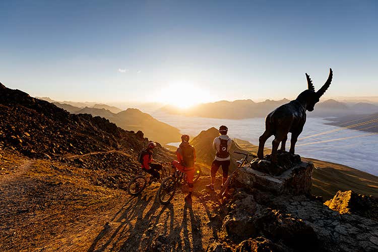 Mountain bikers ammirano l'alba dalla cima Piz Nair (Estate in Engadina St. Moritz Eventi food fino ad ottobre)