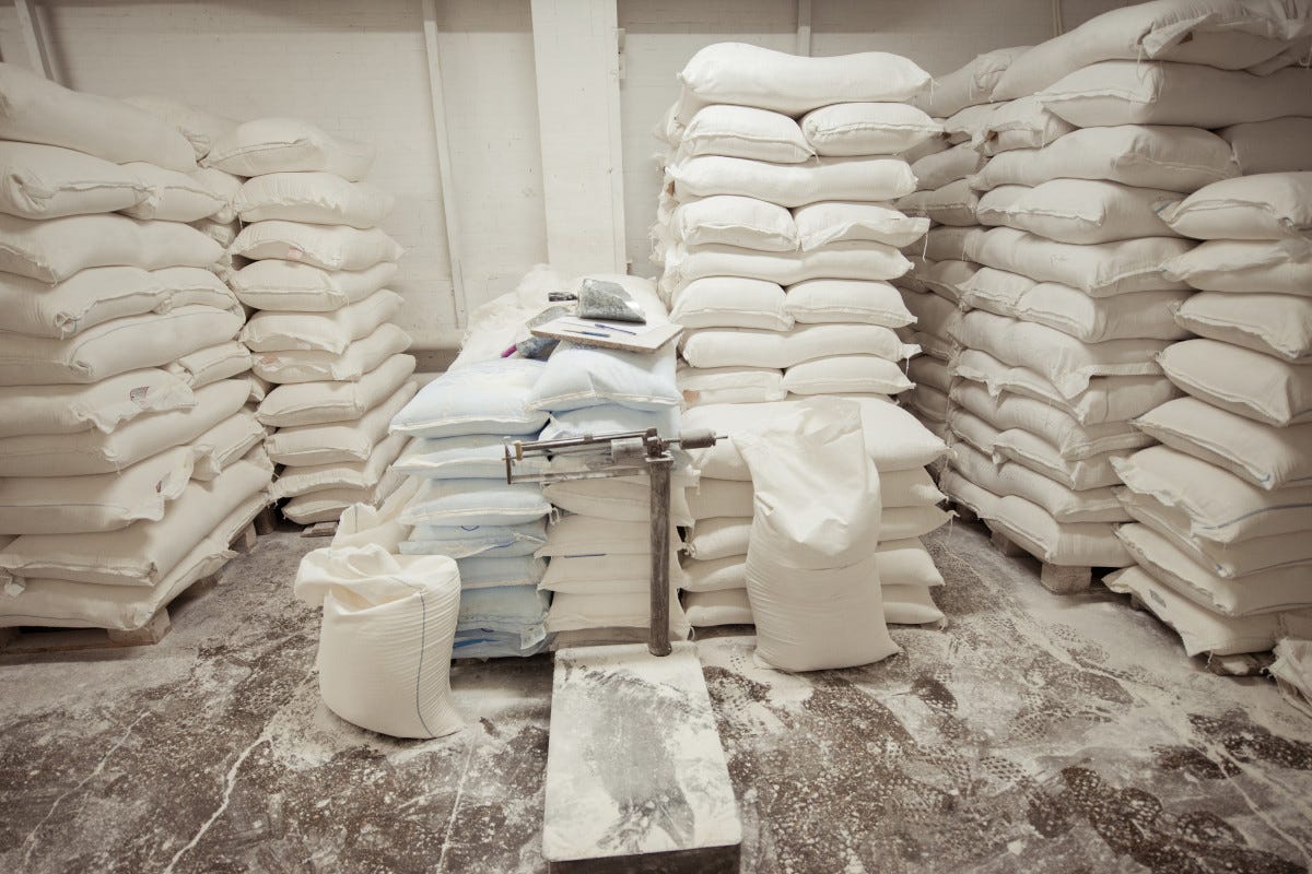 Sacchi di farina stipati in un magazzino Materia prima alle stelle e aziende con le spalle al muro, ecco dove nascono i rincari di farina e pasta