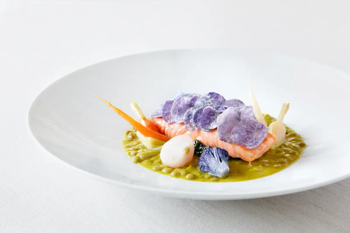 Filetto di salmone su lenticchie alla curcuma, spinaci al brodo di verdure novelle e chips di patate viola