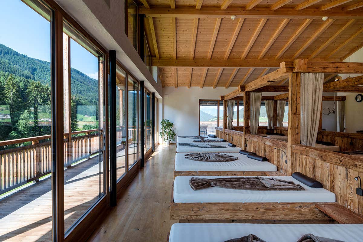 Una delle zone relax dell'oasi wellness, concepita con strutture in legno antico e vetrate a tutta altezza per garantire una disconnessione totale dal rumore quotidiano
