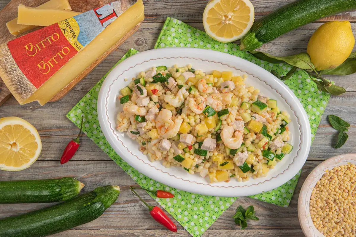 Insalata di fregola con gamberi marinati, spada, zucchine, menta e Bitto Dop
