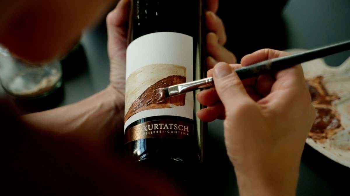 Ogni annata ha un proprio motivo tematico: l'annata 2015 mostra la forte pendenza dei filari di Merlot Tres la creativit&agrave; dell'artista Margit Pittschieler sulle bottiglie