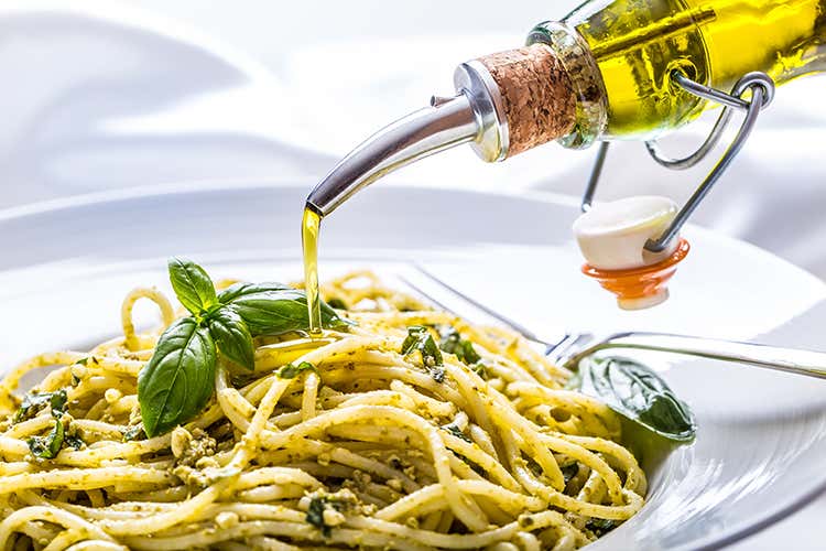 Olio evo su un piatto di pasta al pesto ligure - Liguria: mare, fiori e olio evo Olio evo su un piatto di pasta al pesto ligure - Liguria: mare, fiori e olio evo