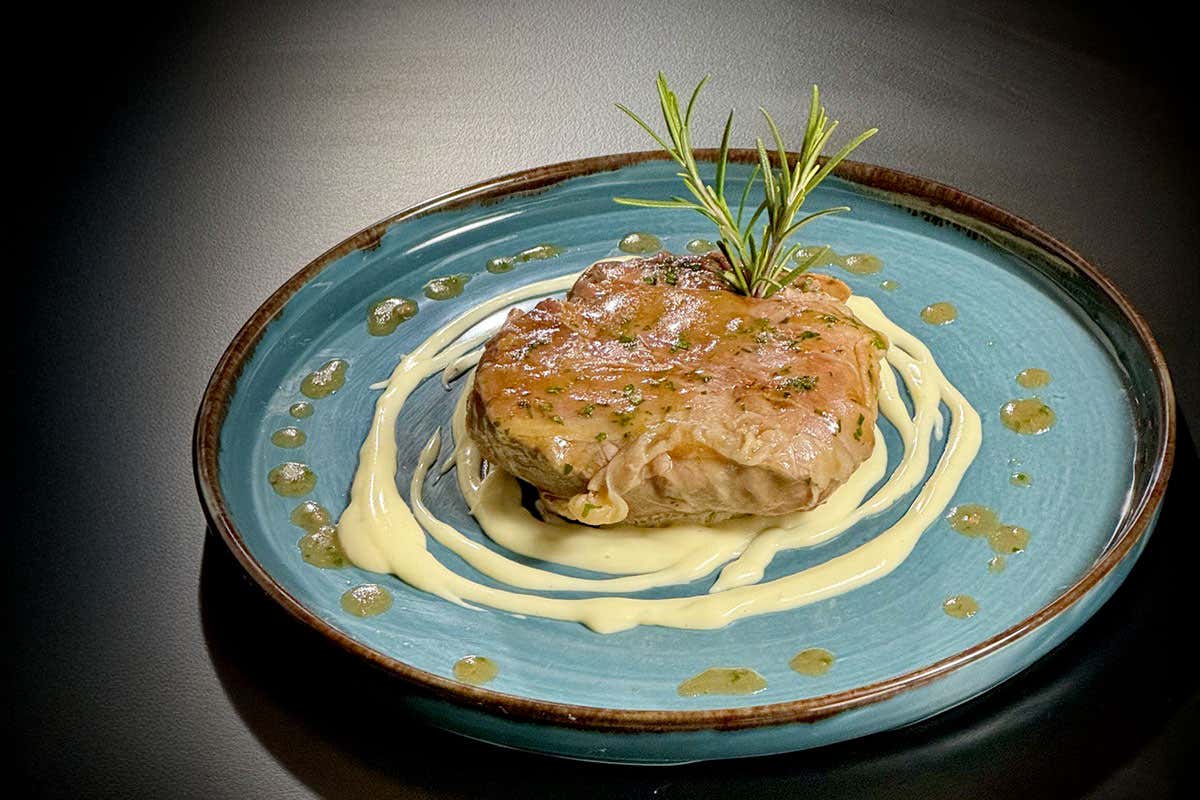 Filetto di manzo in manto di prosciutto crudo su fonduta di Parmigiano Reggiano