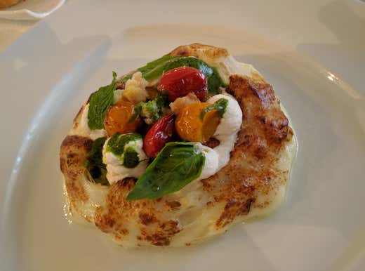 Pizza al contrario con datterini gialli e rossi, basilico, fiocchi di ricotta e fresella