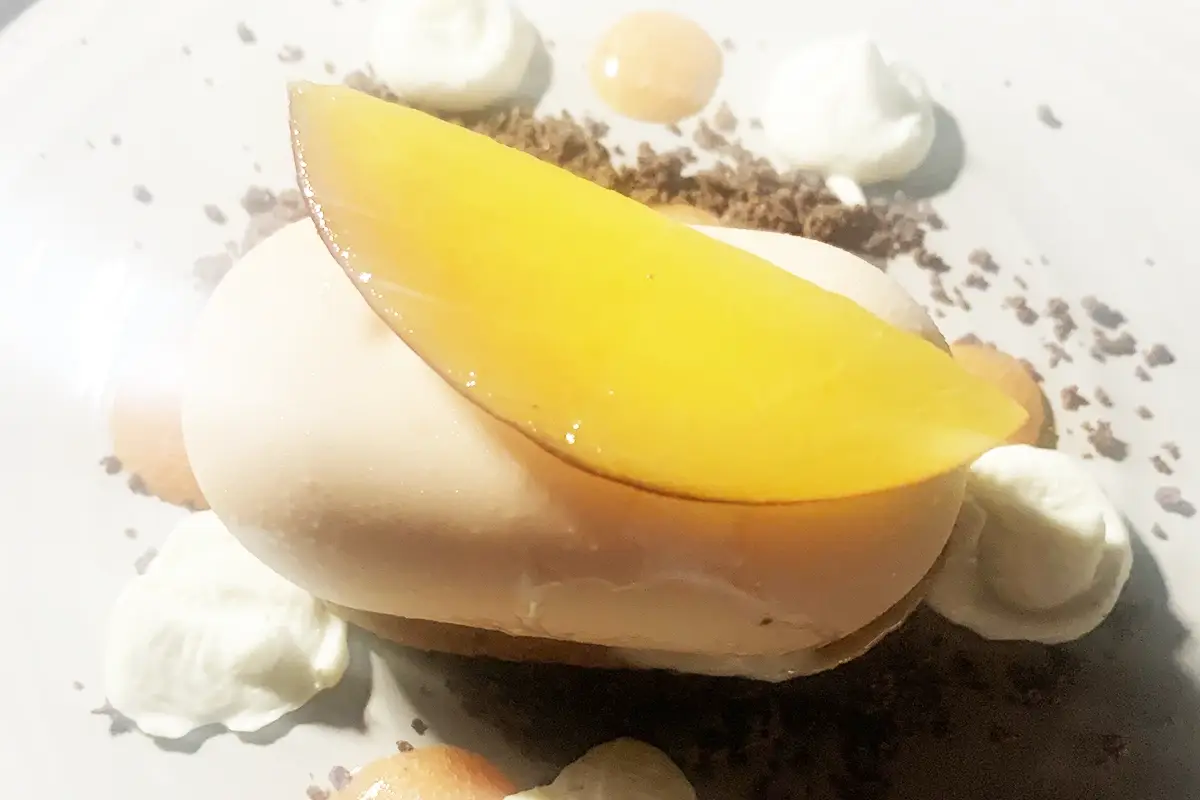 Mousse alla pesca con namelaka al basilico, gel di agrumi e crumble al cioccolato All’Hotel Aleph di Roma il menu estivo è un viaggio di gusto in Italia