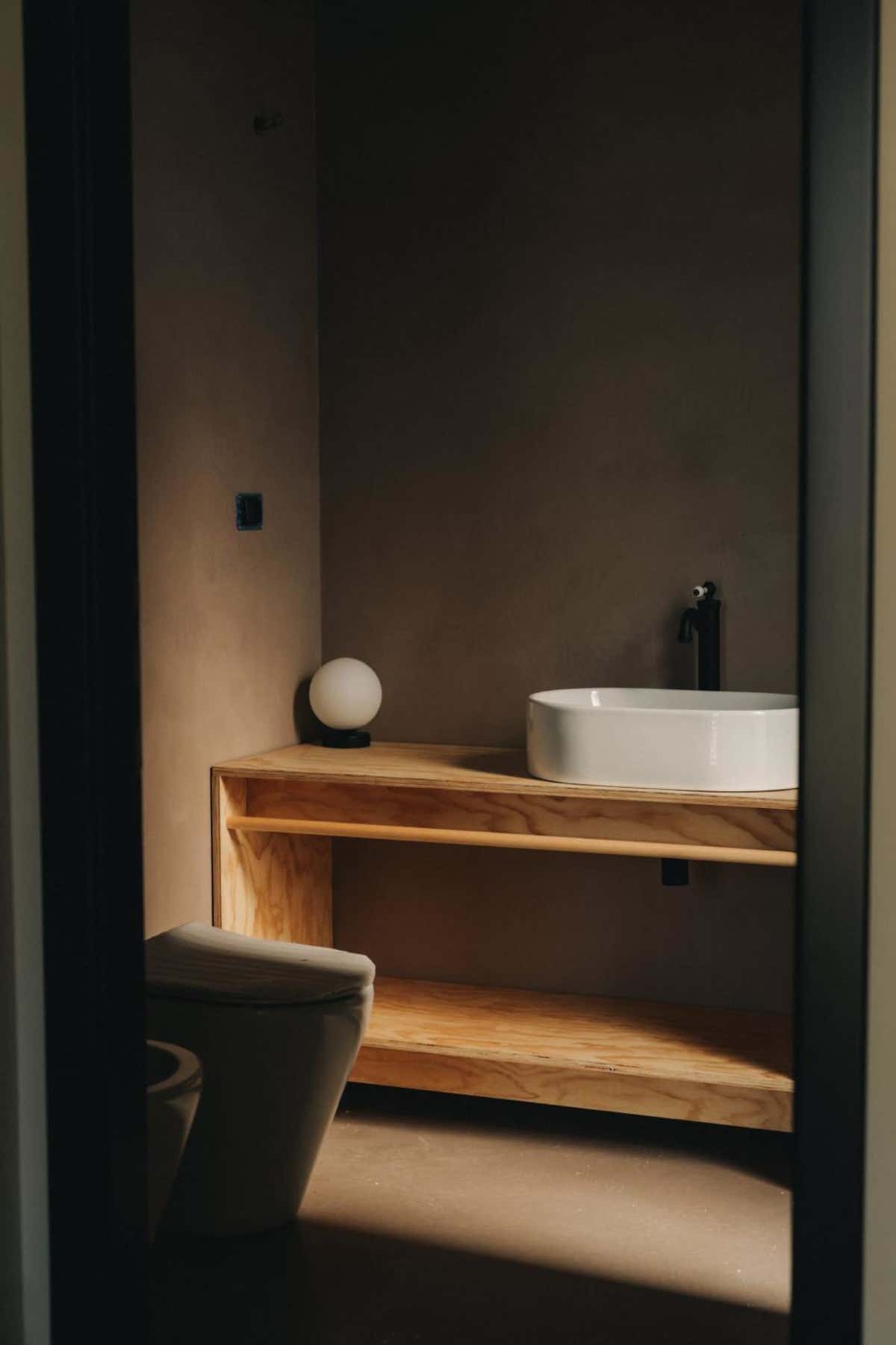 Un angolo di design minimalista e accogliente in bagno, tra legno naturale e geometrie pulite