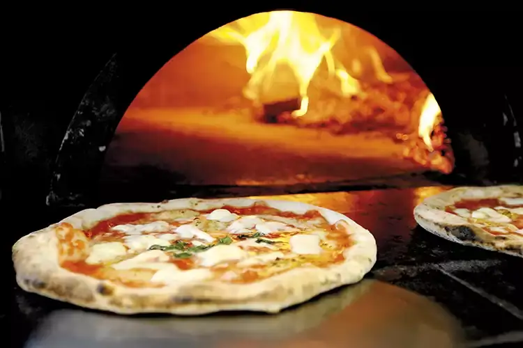 Cottura in forno a legna per una pizza a regola d&rsquo;arte