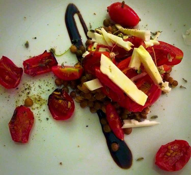 Lenticchie semi germogliate aromatizzate alla menta, zenzero e spremuta d&rsquo;arancia con pomodorini, tumma stagionata pantesca, fiori di scalogno, pepe e lavanda