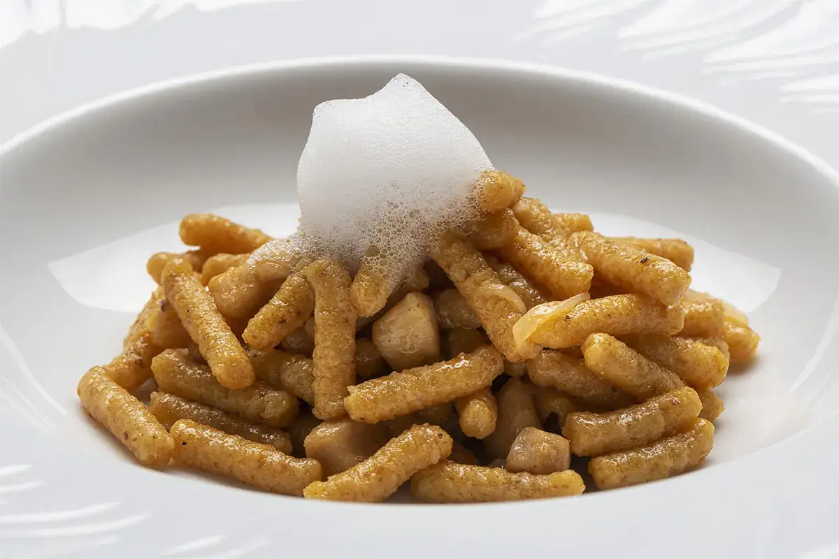Passatelli asciutti con ragout di pollo, uvetta cilena, ristretto di brodo, aria al limone